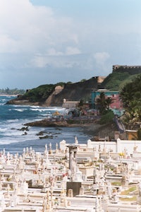 a group of gravestones on a hill overlooking the ocean